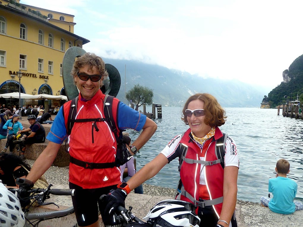 Zwei sehr zufriedene Biker sind nach ihrer Alpenüberquerung für Einsteiger am Hafen von Riva angekommen