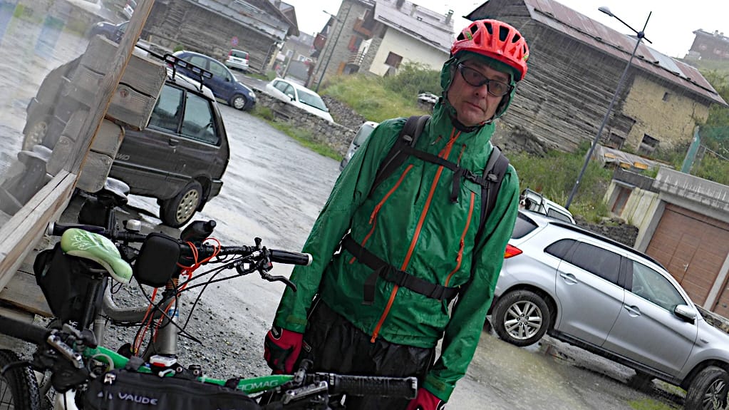 Bei der Umrundung des Ortler Massivs steht ein Biker stoisch im Regen