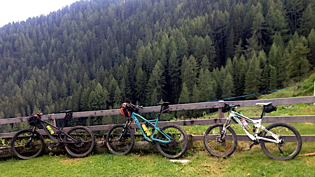drei Mountainbikes stehen am Weidezaun der Malga Dignas
