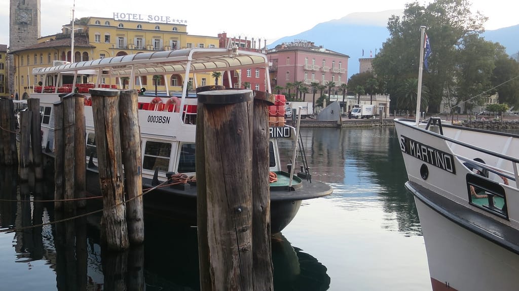 Zwei Ausflugsboote im ruhigen Wasser des Hafens von Riva del Garda - Gardasee