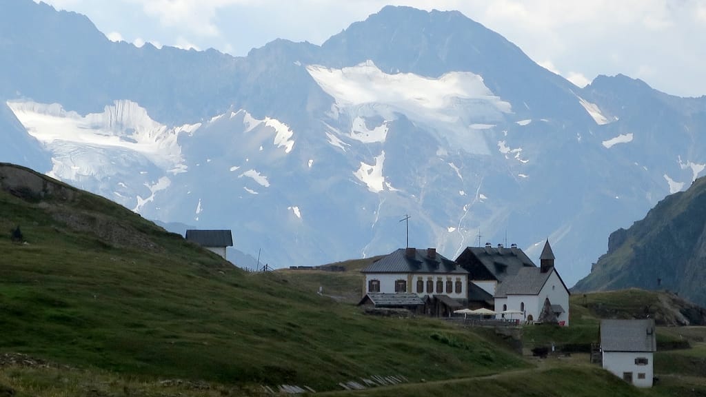 Die Gebäude St. Martin am Schneeberg und die Schneeberghütte vor Bergkulisse