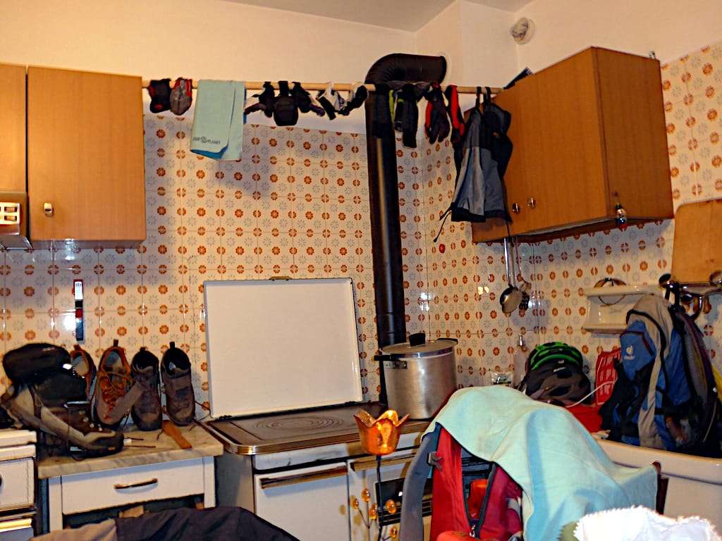 In einer Küche hängen viele Kleidungsstücke zum Trocknen
