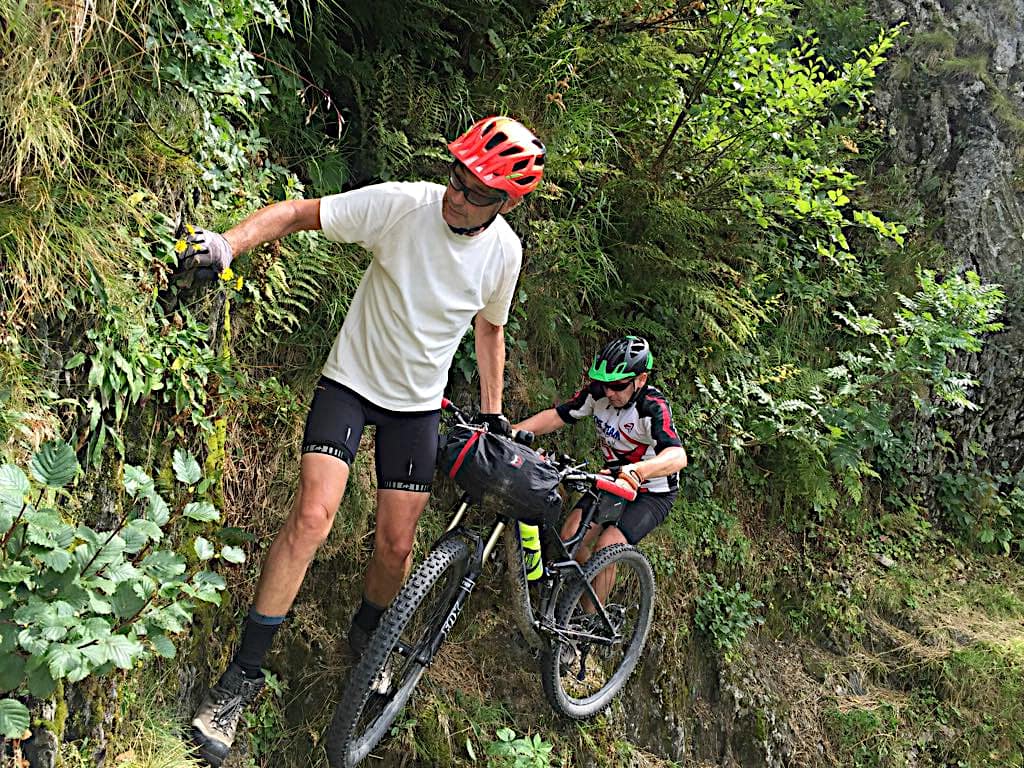 Zwei Biker überwinden ein fehlendes Stück der Via Alpina wie der Karnische Höhenweg hier auch heißt